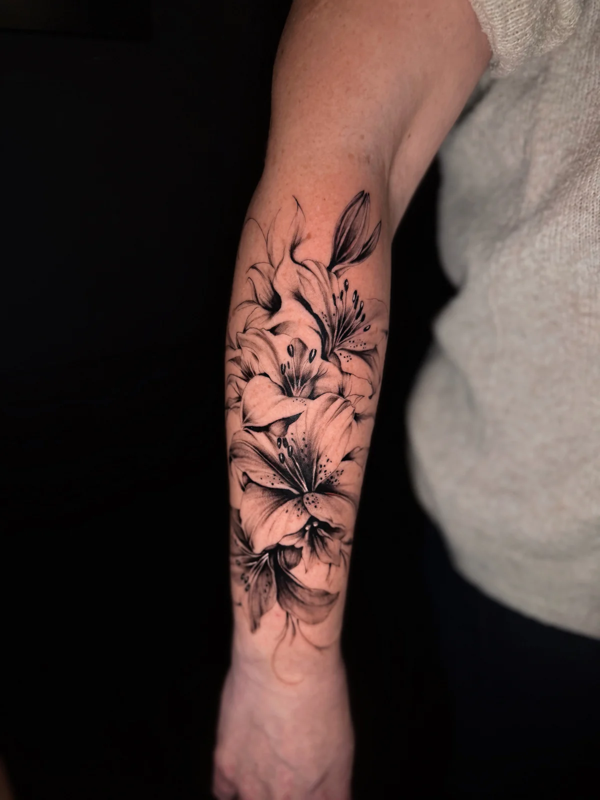 Detailreich schattiertes Black-and-Grey-Blumentattoo am Unterarm – Arbeit von Merci, Skin City Tattoo.