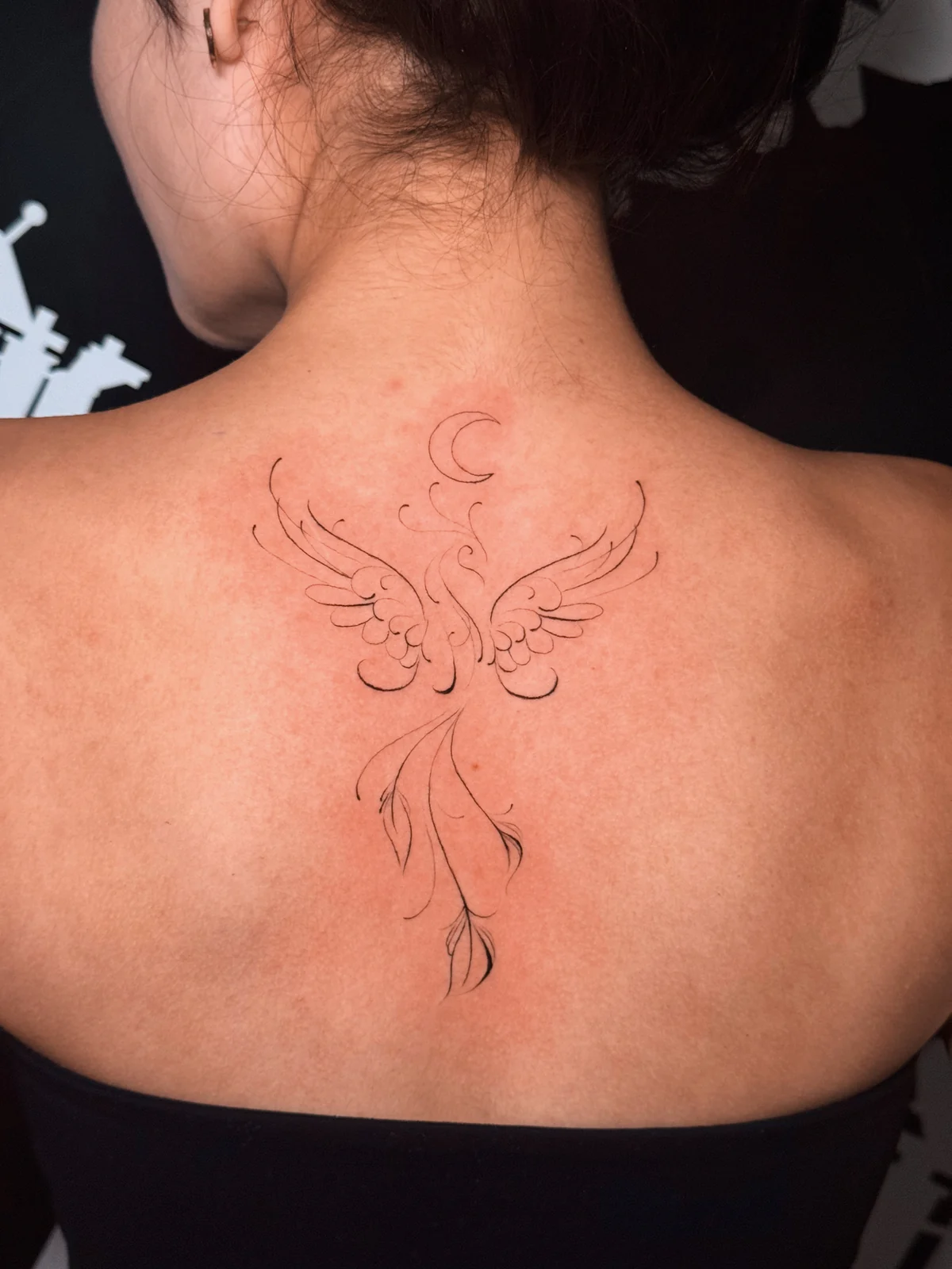 Symmetrisches Fineline-Tattoo mit Flügeln, feinen Ornamenten und Mondsichel im Nacken – Arbeit von Merci, Skin City Tattoo.
