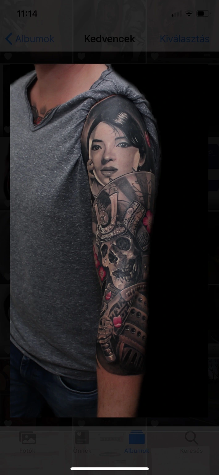 Schwarz-graues Oberarm-Tattoo mit Frauenporträt und Samurai-Schädel